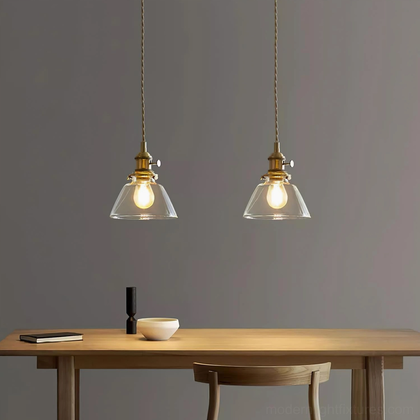 Pair of Jasmine fluted cone glass pendants with warm bulbs over wooden work table, industrial modern style