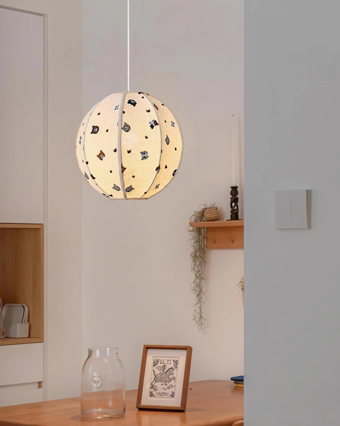 Spherical fabric pendant light with animal motifs in minimalist kitchen nook, wooden shelves, side three-quarter view