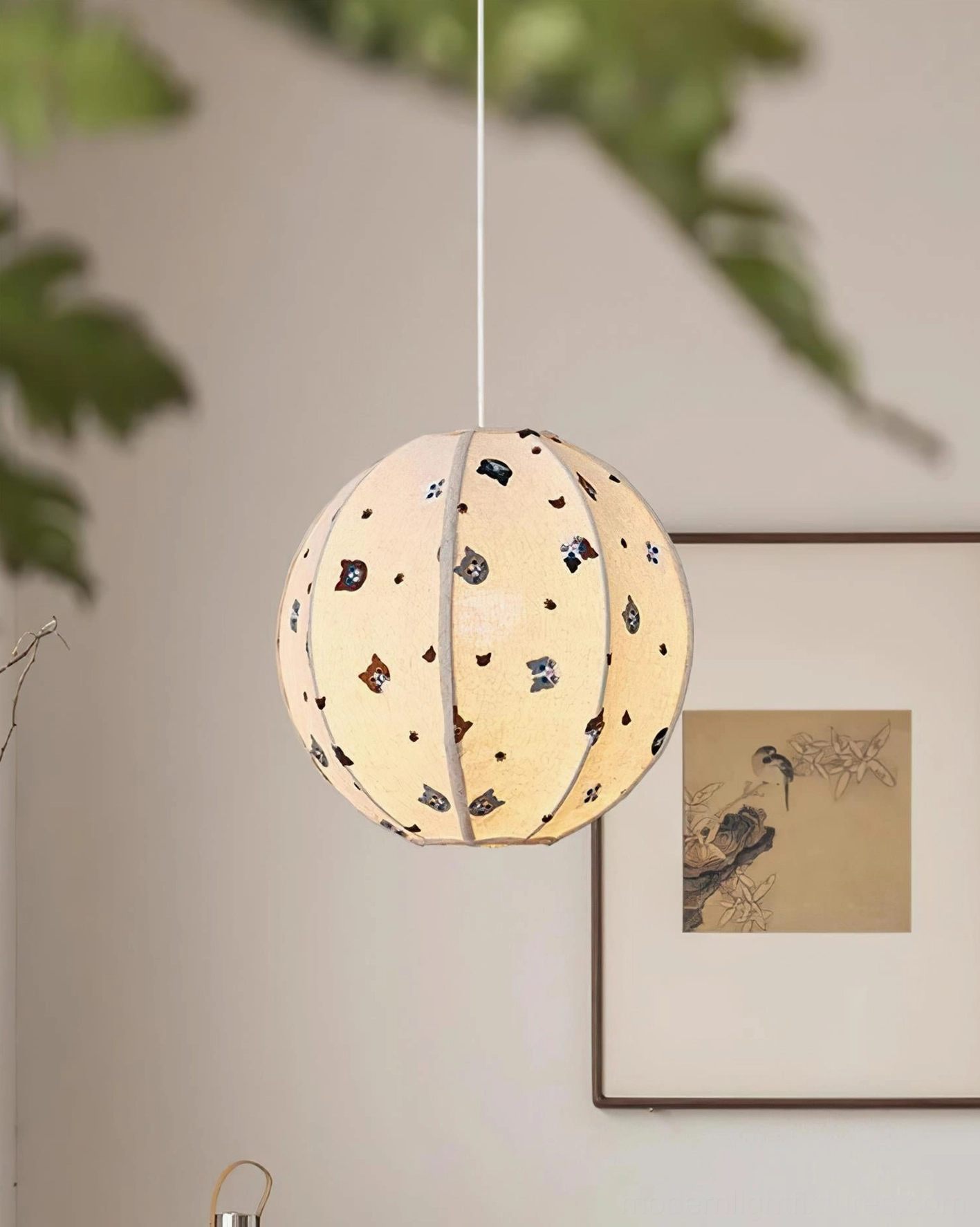 Illuminated Jayne cat pendant light in modern minimalist interior with warm ambient glow, white wall with artwork