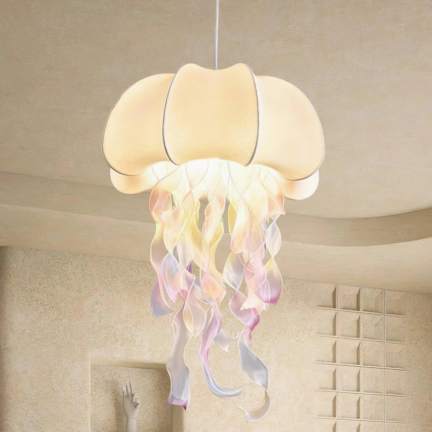 Close-up detail of jellyfish hanging lamp showing stitched fabric shade and flowing iridescent gradient tassels with warm glow