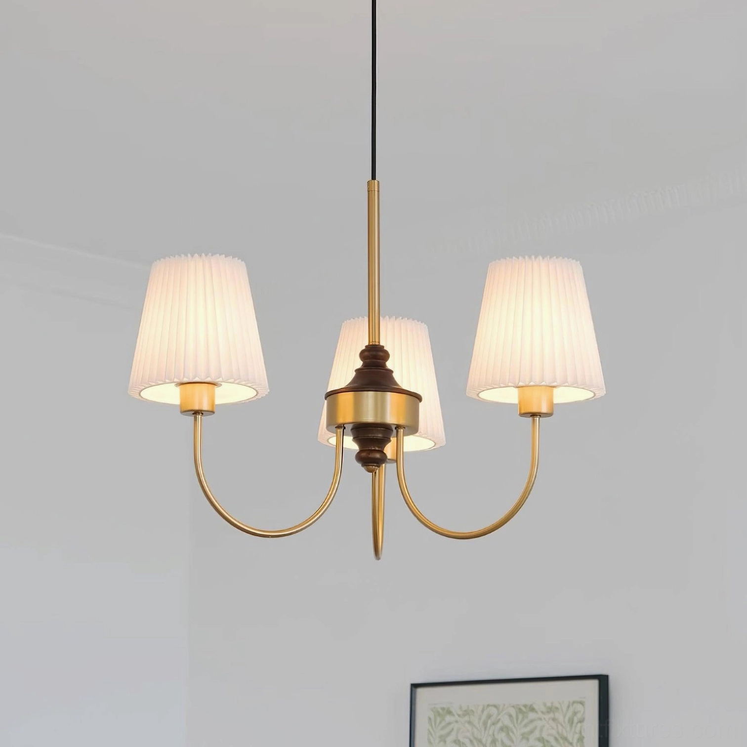 Jeremiah 3-light arm chandelier with brushed gold curved arms and pleated warm fabric shades against minimalist wall