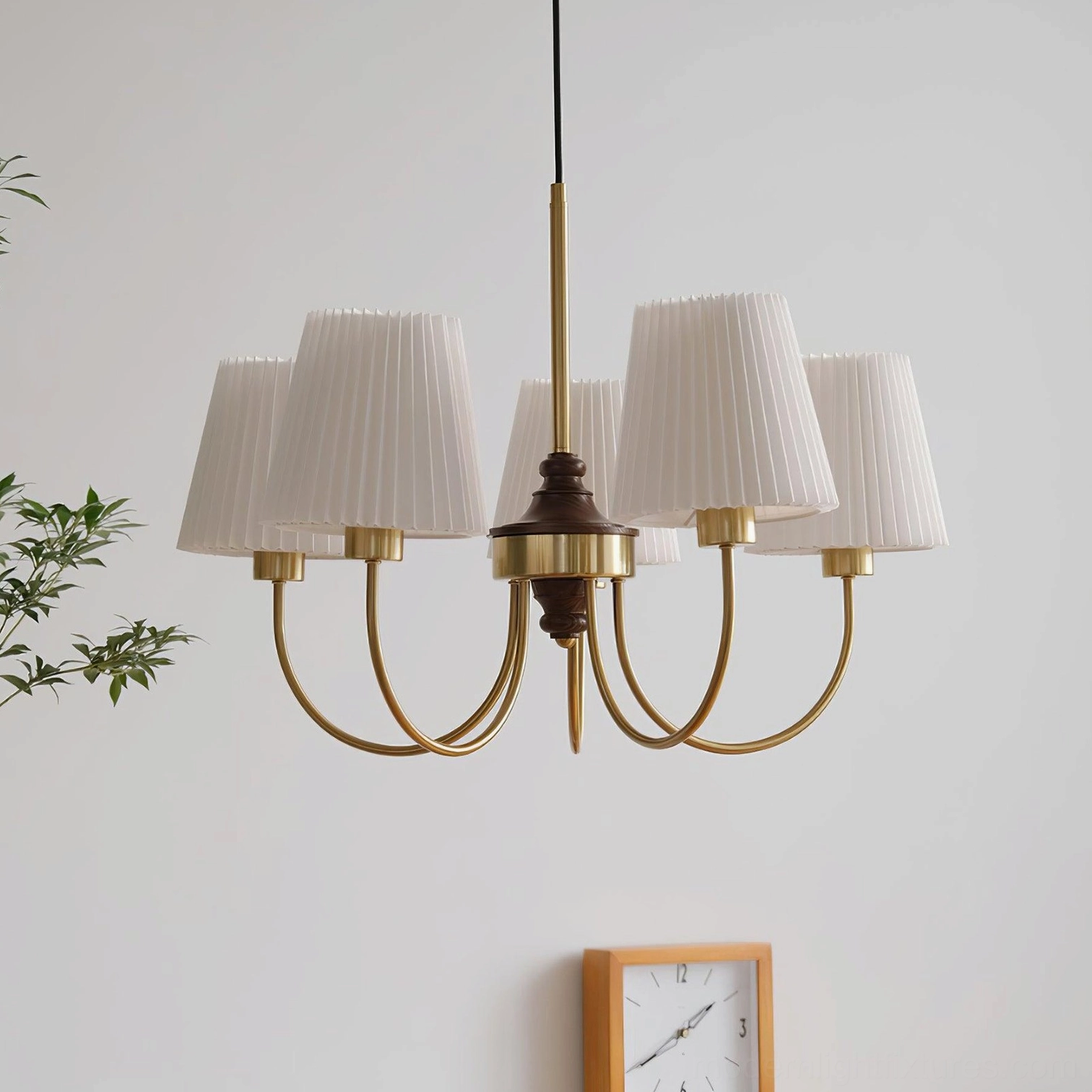 Modern Jeremiah 5-light pleated shade chandelier with brushed gold frame and white fabric shades above green plant decor