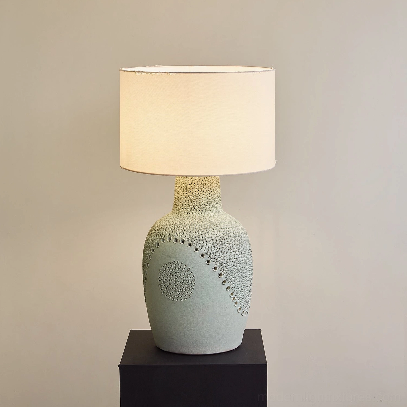 Side view Jordyn matte sage ceramic table lamp showing curved dot embossing pattern and unlit fabric shade