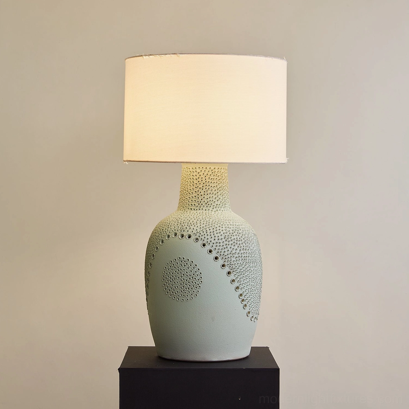 Illuminated Jordyn ceramic table lamp, matte sage base with embossed constellation dots, warm interior lighting