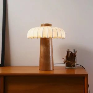 Lit Juego wooden table lamp on bedroom nightstand with warm glowing light and dried flower decor