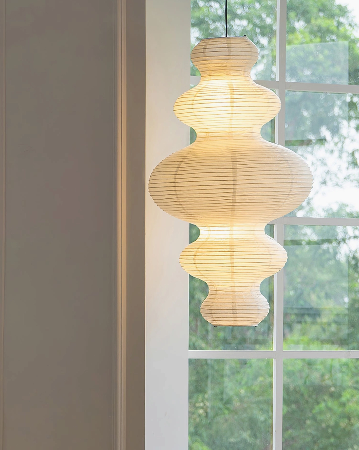 Juni pendant light glowing near window - soft paper shade creating shadowless illumination