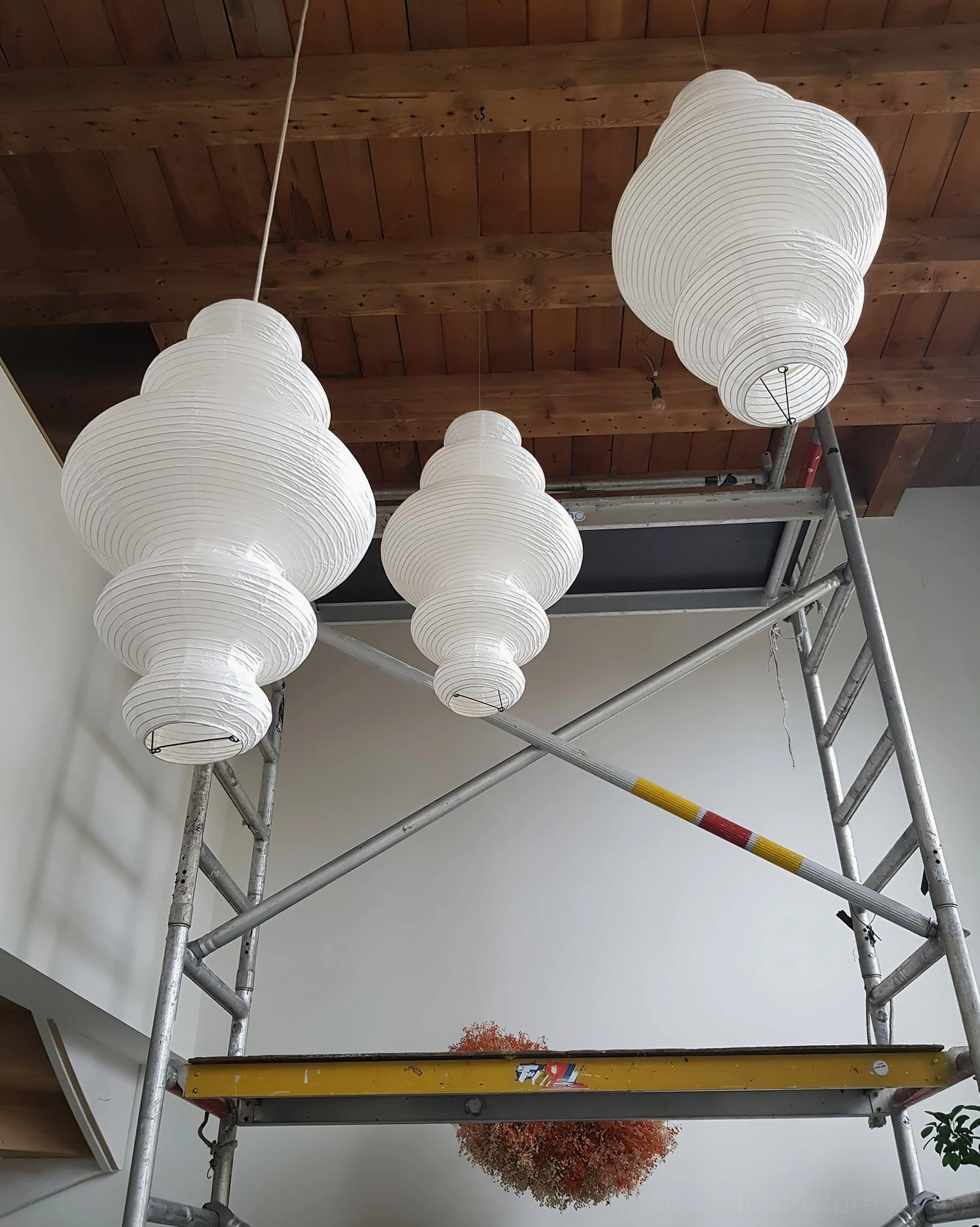 Juni paper pendant lamp glowing in softly lit interior space - warm ambiance