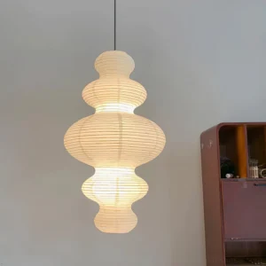 Juni pendant lamp illuminated in contemporary living room - soft warm paper light with bamboo frame