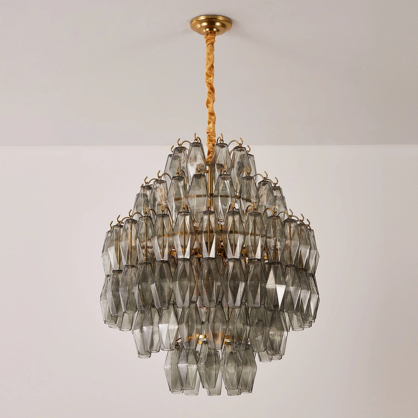 Smoke gray tiered glass chandelier with gold metal frame, contemporary luxury lighting fixture detail