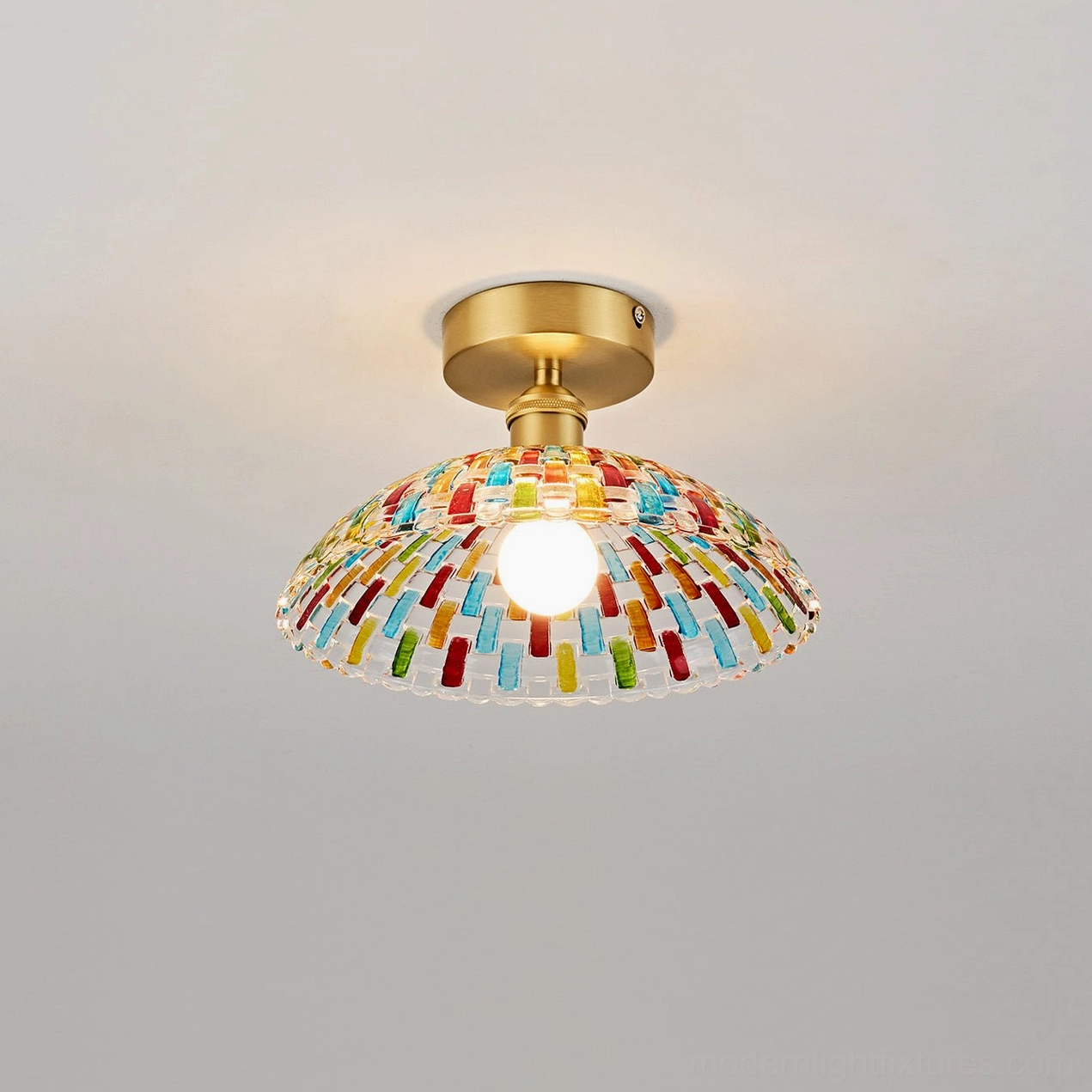 Kaleido hand-cut glass ceiling lamp front studio view with lit exposed bulb, compact dome glass shape, brass ceiling hardware