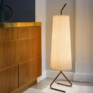 Tall Kalmar floor lamp with curved metal tripod base in luxury entryway interior design setting