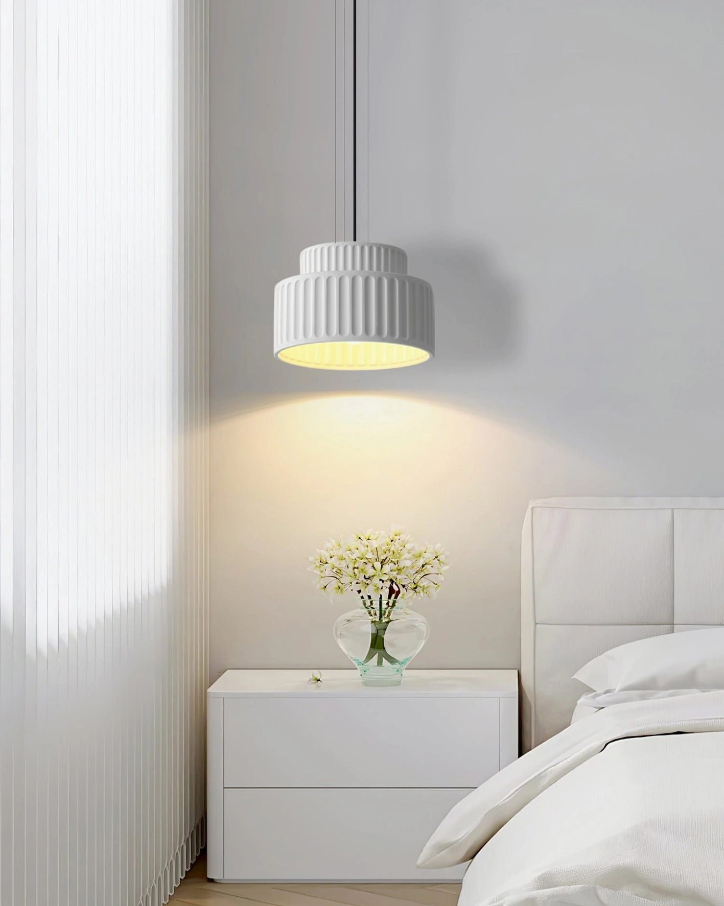 Light off-white Kami pleated pendant in cozy modern bedroom with nightstand, bedside hanging perspective