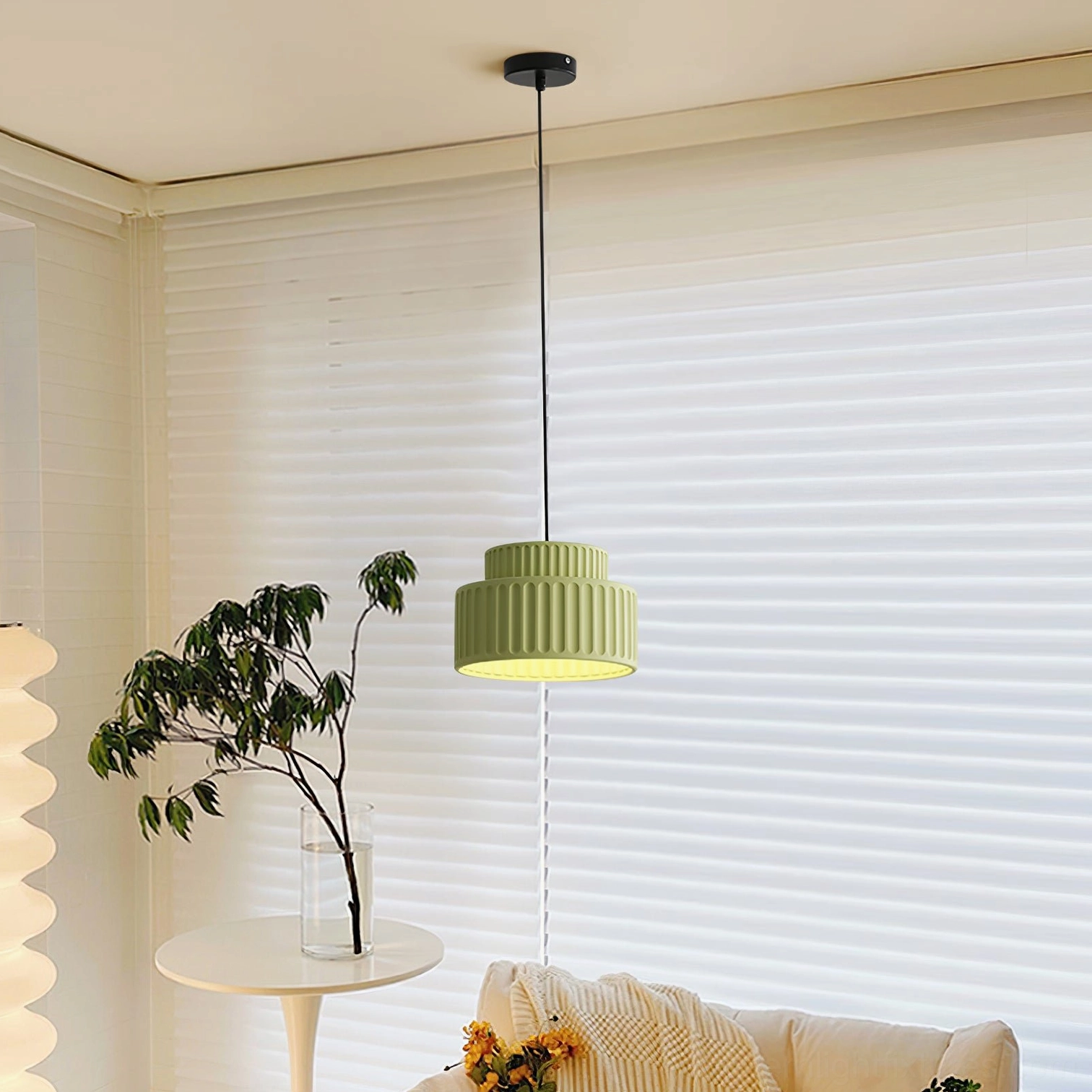 Sage green Kami pendant fixture in modern living room with roller blinds, side angle view showing cylindrical layered shape