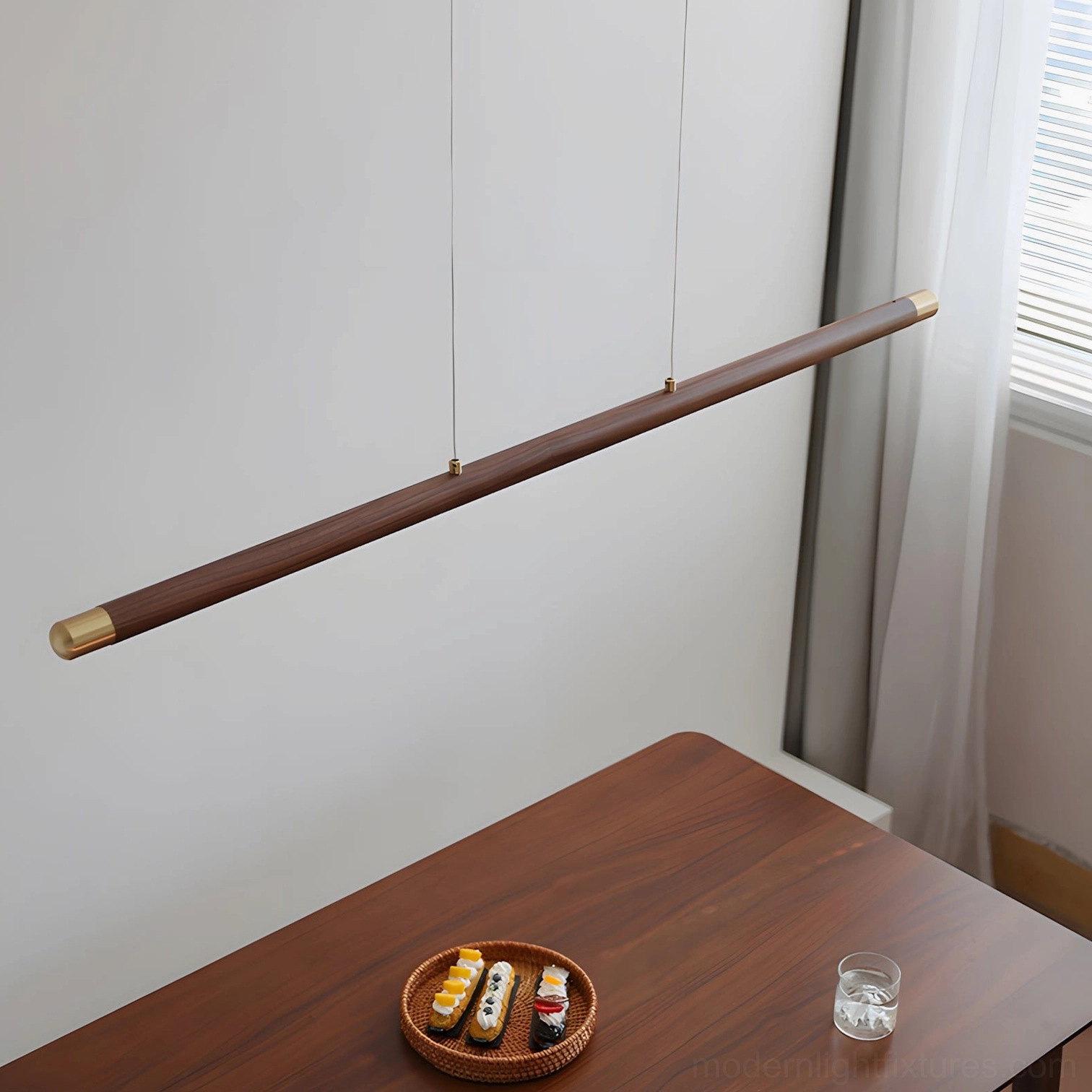 Close-up detail of Karsen linear pendant showing walnut wood body, brass end caps and suspension cables
