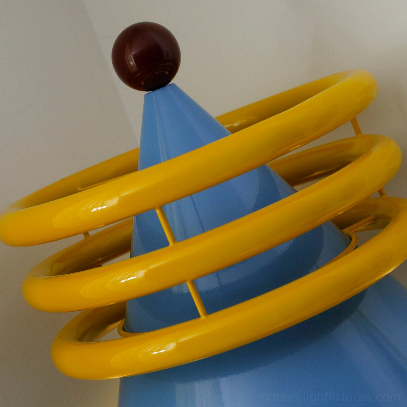 Modern floor lamp with distinctive yellow circular rings and blue cone in residential interior design