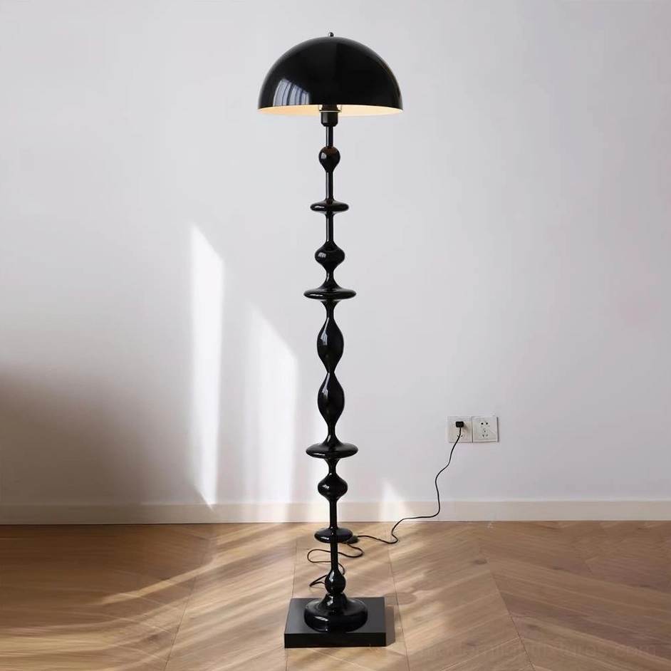 Matte black Keira modern floor lamp with geometric stacked curves and square metal base full length shot on wooden floor