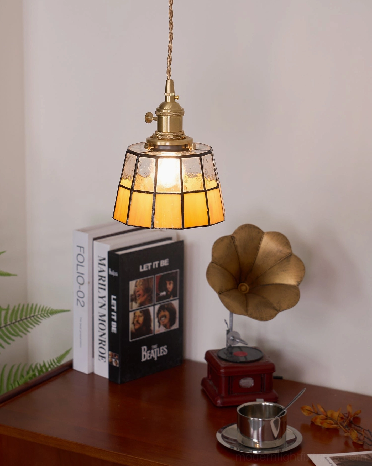 Keito stained glass pendant light with warm amber panels illuminated in vintage industrial setting