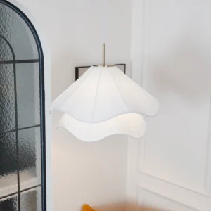 Kendra pendant lamp side view hanging in French-style home with arched glass doors and off-white wall panels, white pleated shade