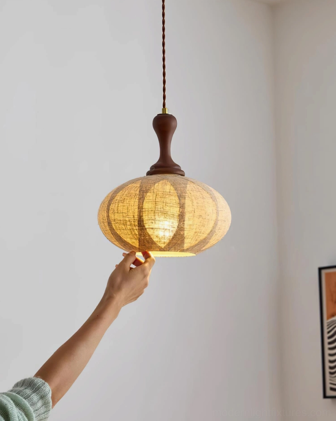 Kenso fabric pendant lamp close-up handheld view, segmented linen shade with warm rustic lighting