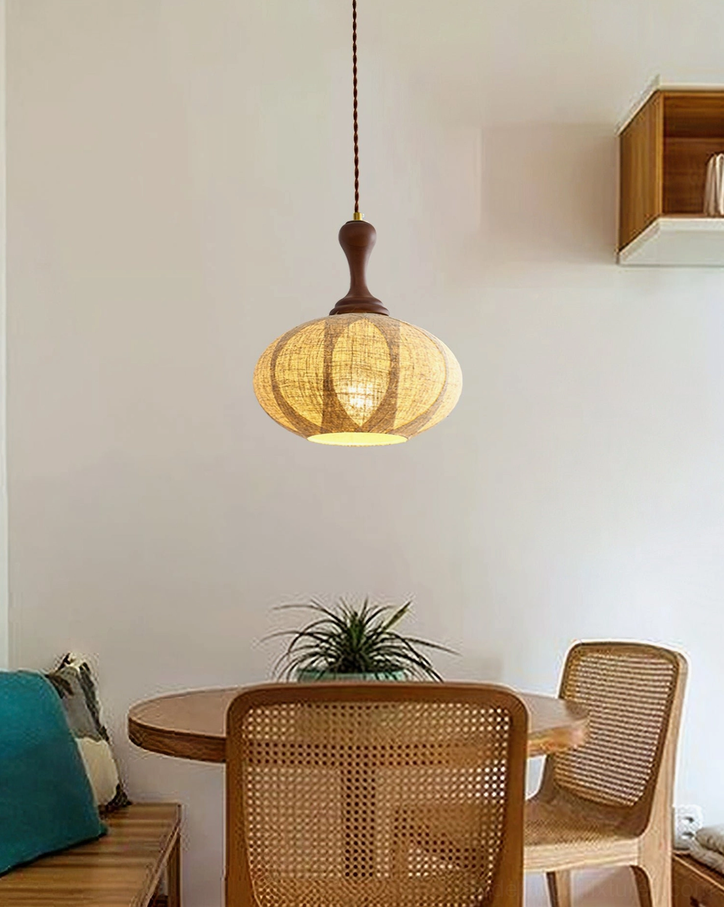 Warm fabric pendant light in bohemian dining nook with rattan chairs and rustic wooden table