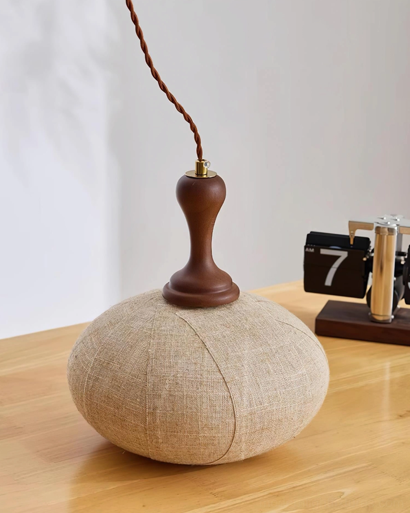 Fabric pendant light fixture showing walnut wood construction and light brown linen shade quality