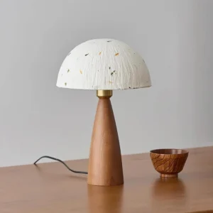 Walnut Kent table lamp three-quarter view on wooden desk with decorative wooden bowl and warm lighting