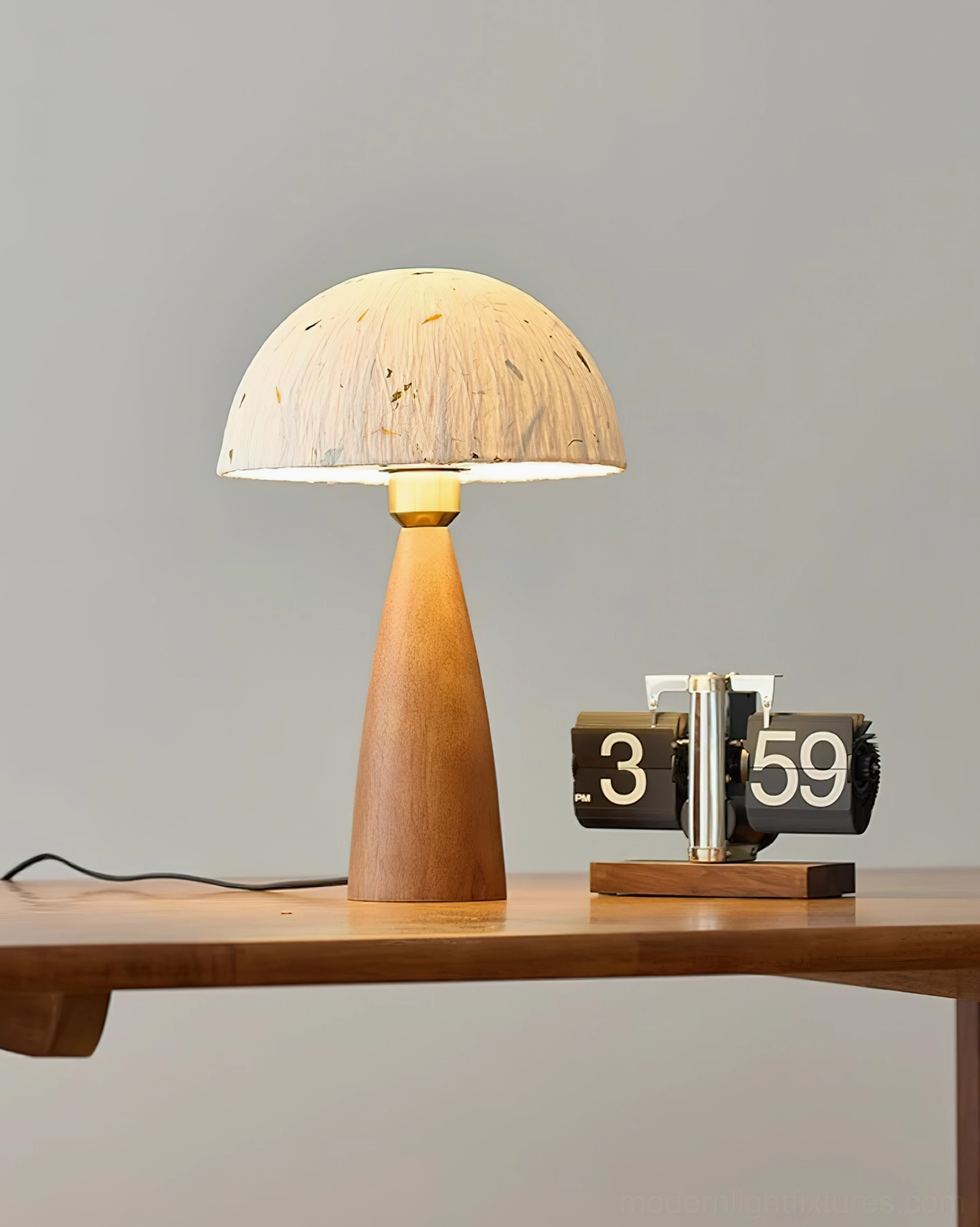 Illuminated Kent wood table lamp glowing softly on wooden desk with flip clock showing boho minimalist aesthetic