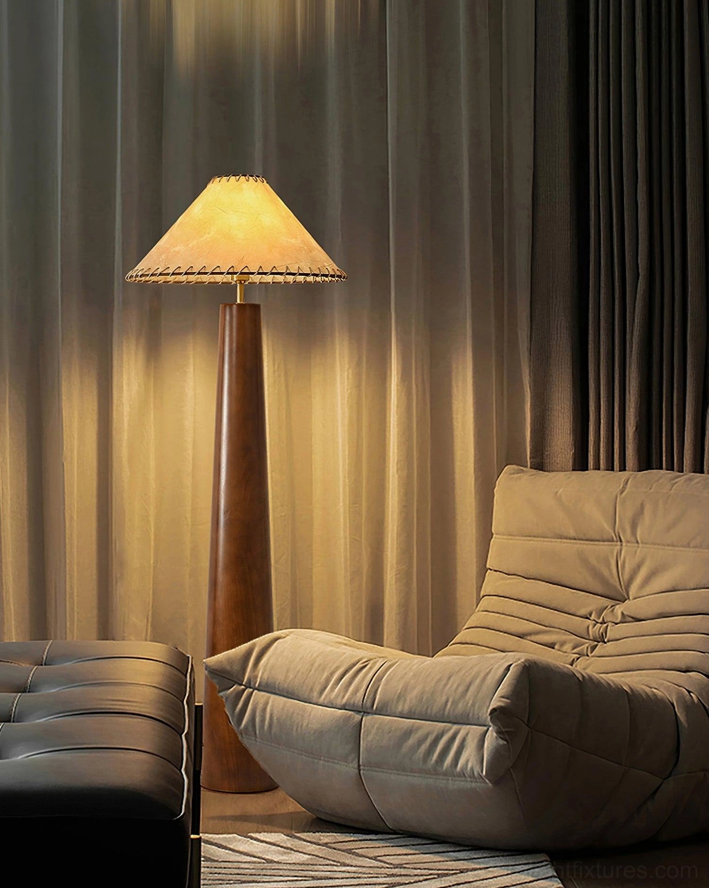 Kibo handcrafted wood floor lamp beside gray sofa and dark curtains, side view with warm wall-wash lighting effect