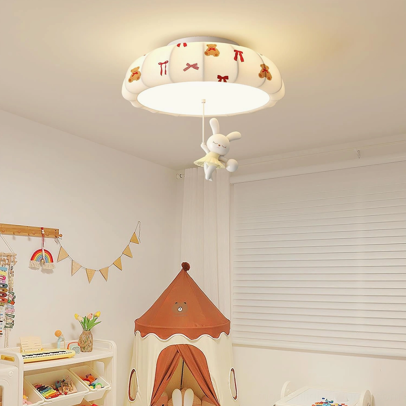 Indoor children's bedroom ceiling light fixture mounted overhead, showing warm ambient lighting from pumpkin shade with hanging rabbit plush toy decor
