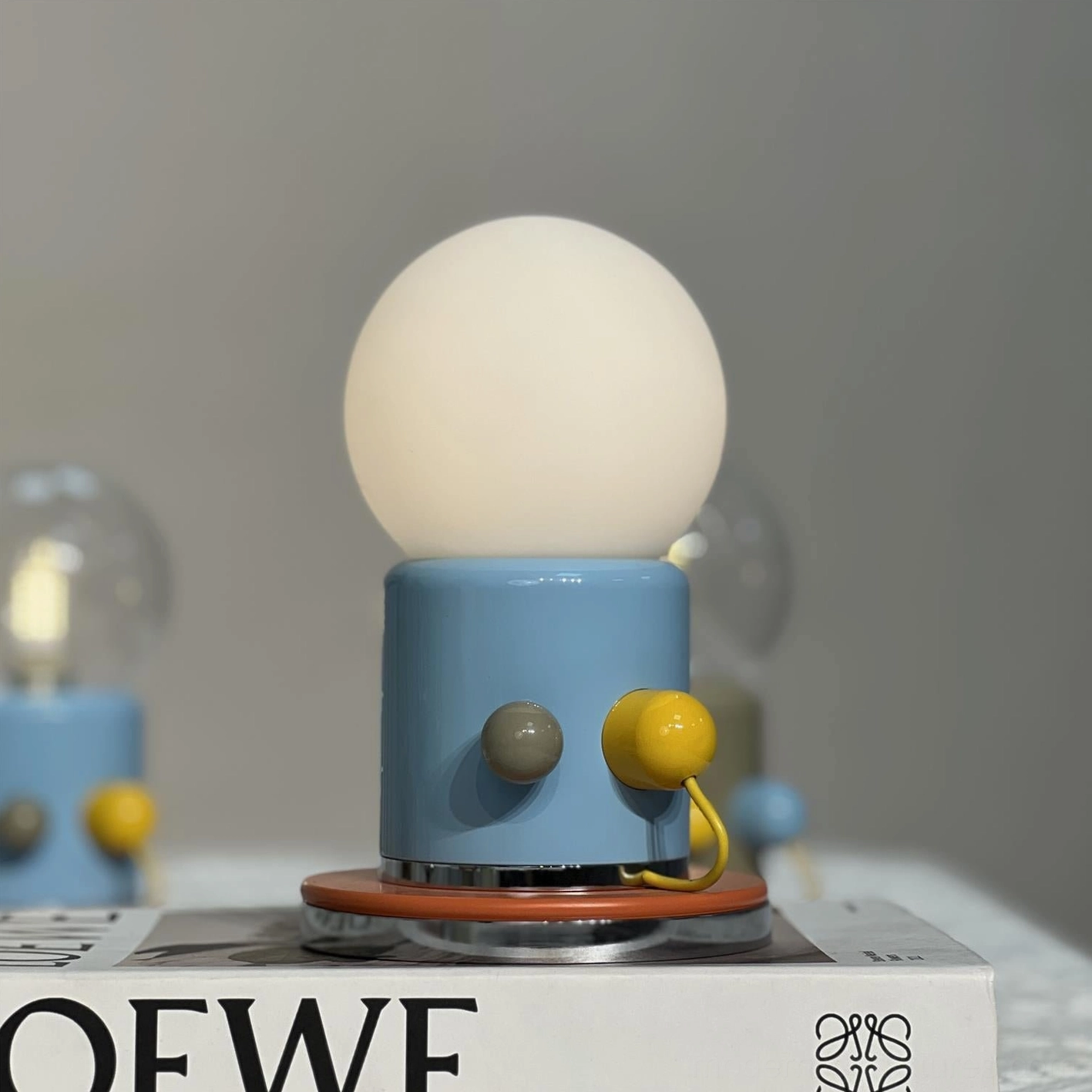 Compact Kiely touch table lamp with blue ceramic base displayed on desktop shelf styling