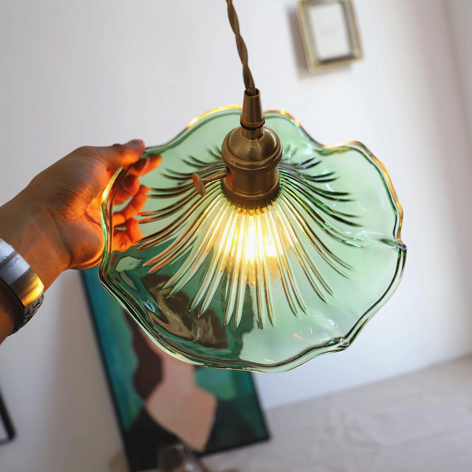 Kinney green ribbed glass pendant lamp close-up showing scalloped glass edge and warm incandescent bulb glow
