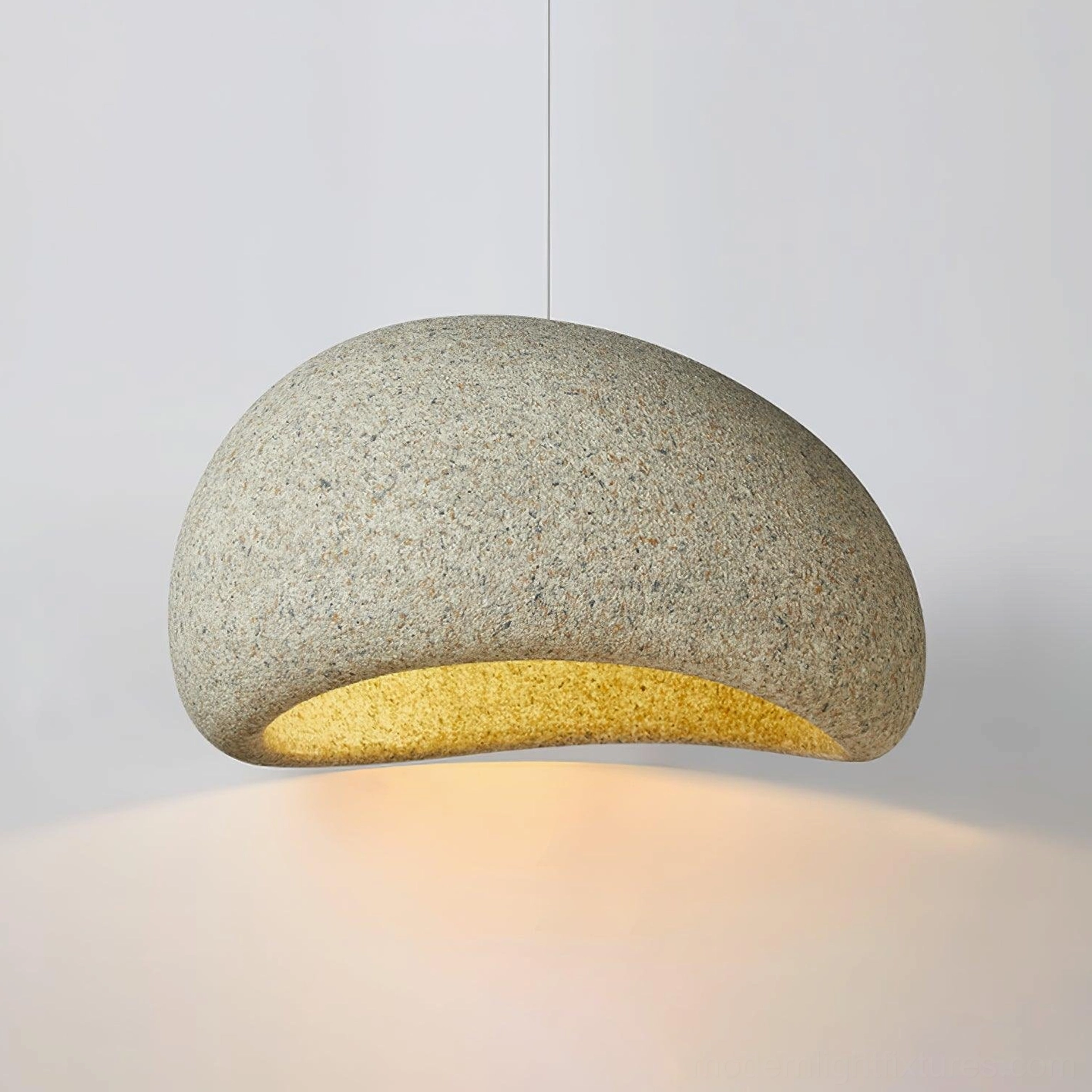 Beige sandy-textured Kioto pendant lamp close-up showing coarse speckled surface and warm glow