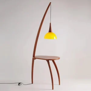 Kirby arc lamp with side table, showing curved wooden frame and yellow conical glass shade from side angle