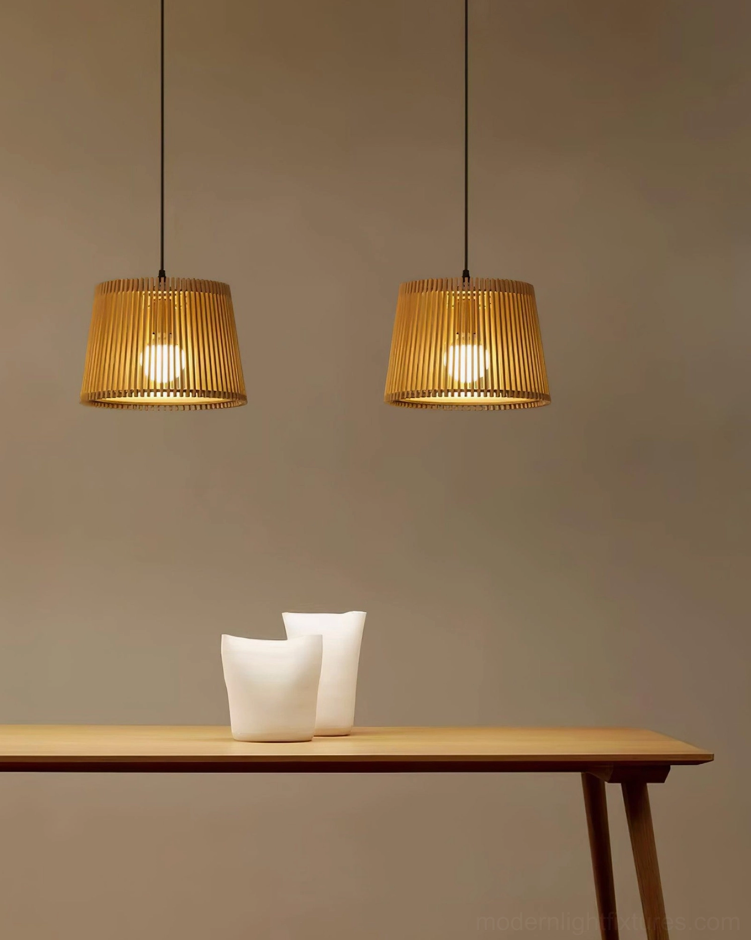 Dual Kitami pendant fixtures above dining table with warm lighting in contemporary dining space