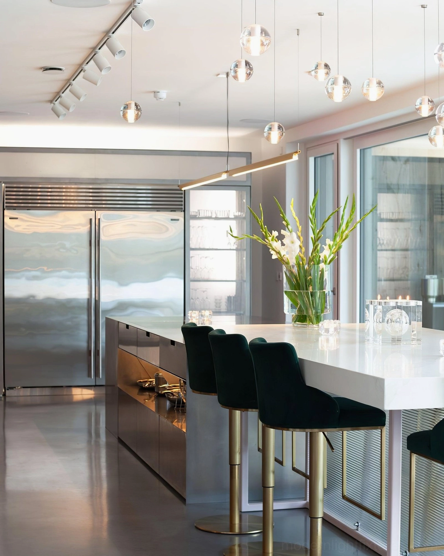 Modern pendant lights suspended above kitchen island with clear crystal shades in contemporary kitchen