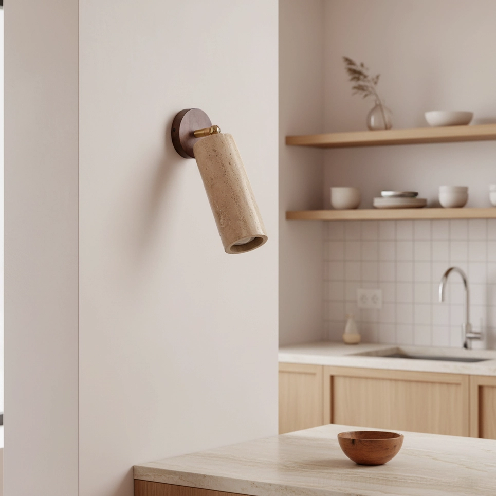 Mireille travertine wall sconce installed in kitchen prep zone with dark wood backplate and white subway tile backdrop