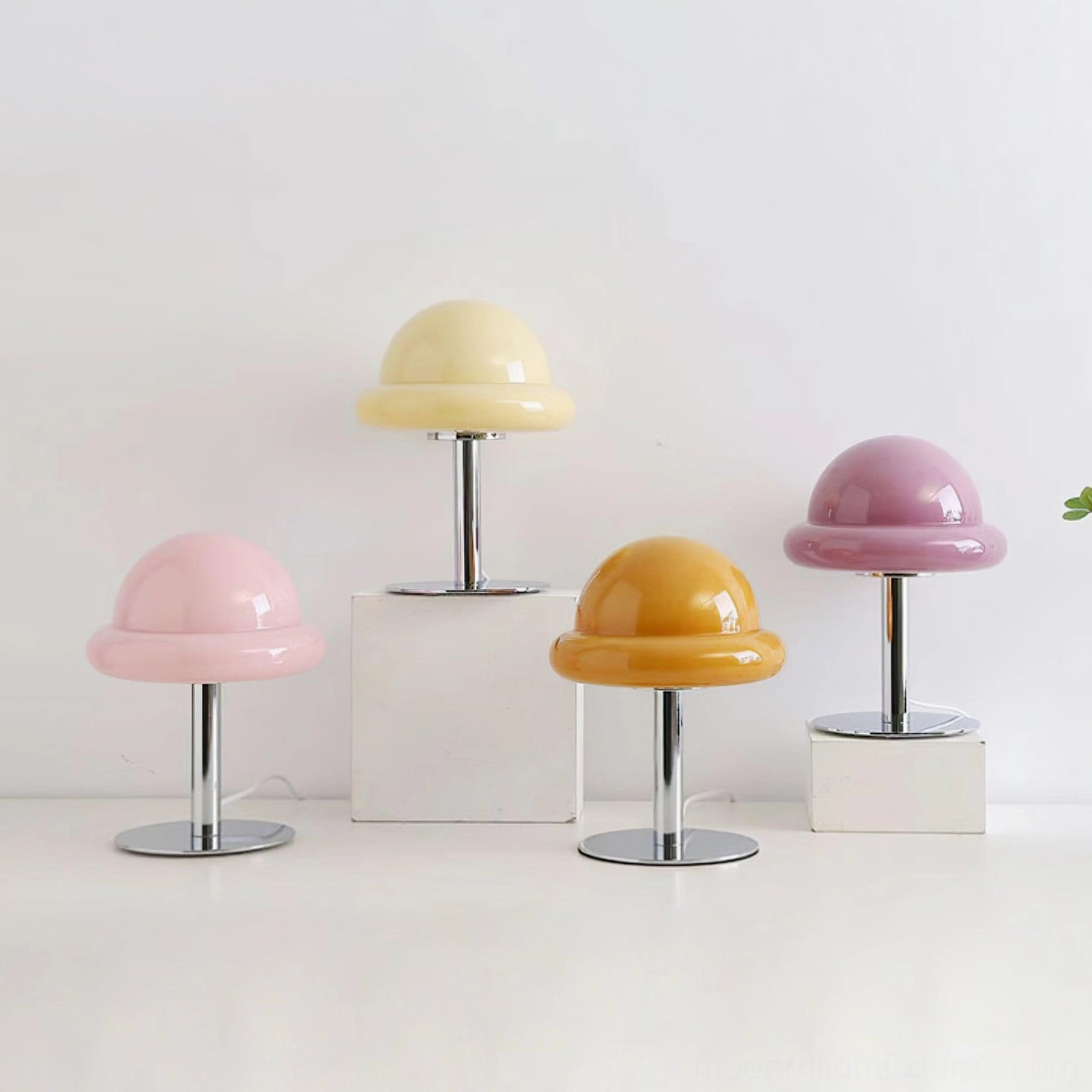 Multiple color variants of Kleine mushroom table lamp in pastel and jewel tones arranged on minimalist white surface