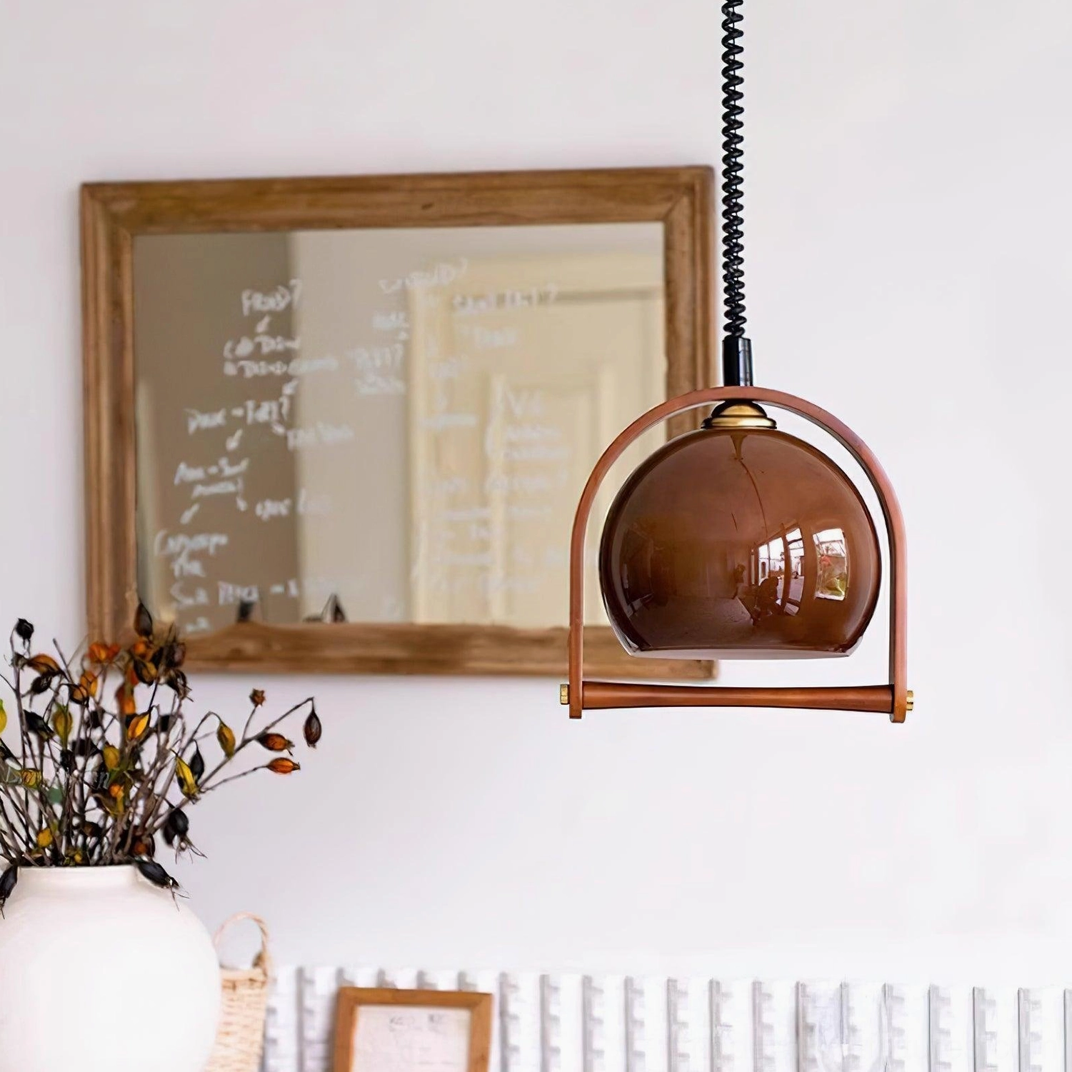 Kleine adjustable pendant light hanging in study space with brown glass shade and wooden frame reflecting classic design