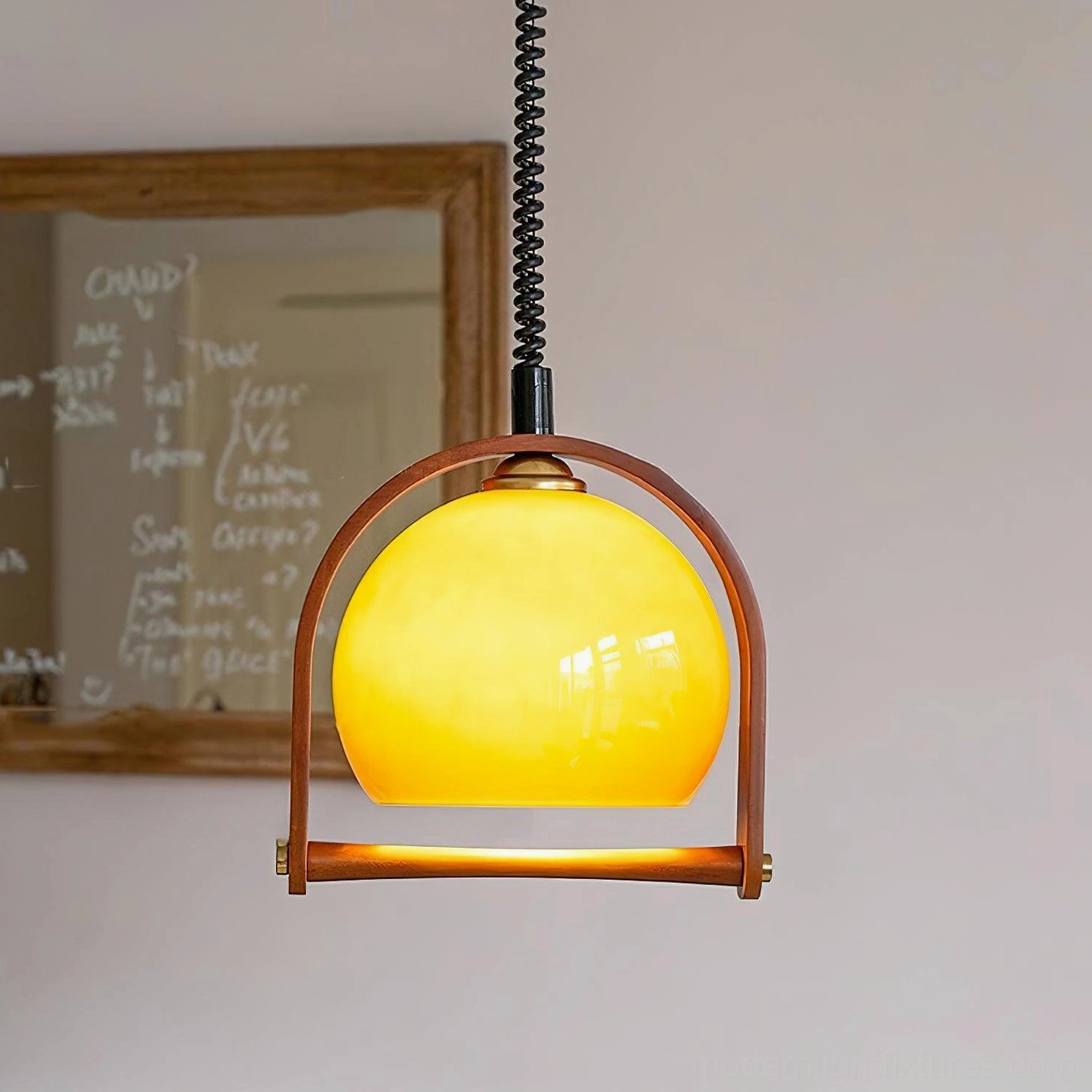 Kleine stretchable pendant lamp with yellow spherical glass shade and retro vintage wooden frame in study room setting