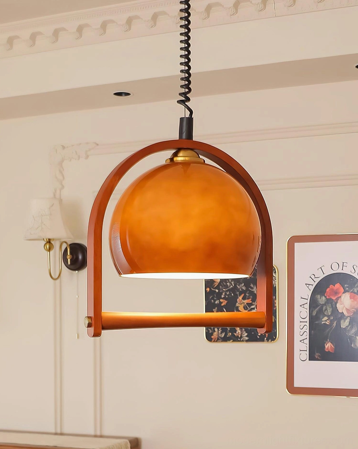 Kleine pendant lamp with orange-brown glossy spherical glass shade in retro living room with wall art decor