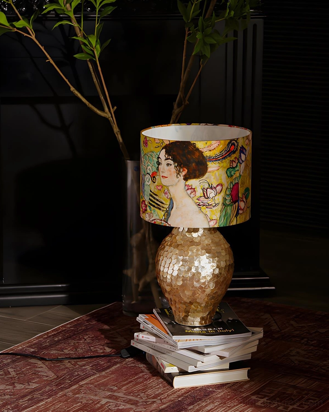 Klimora lamp positioned on stacked books in luxurious home interior with warm ambient lighting and dark walls