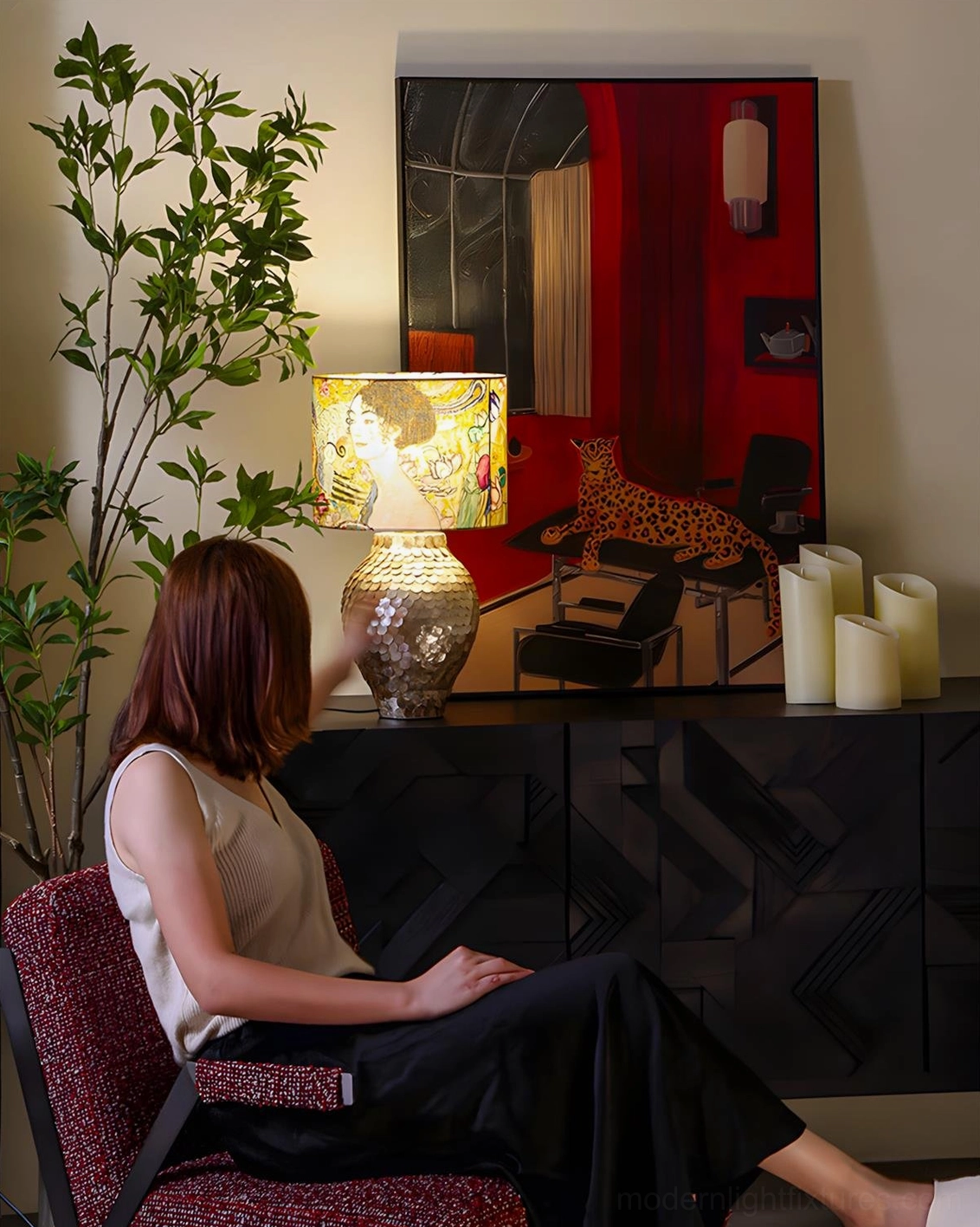 Klimora table lamp on living room sideboard with red wall art, potted green plant, and woman in modern interior design context
