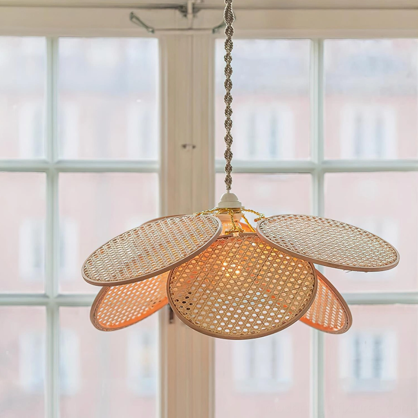 Illuminated Kloe rattan petal pendant light showing warm glow through woven natural rattan shade
