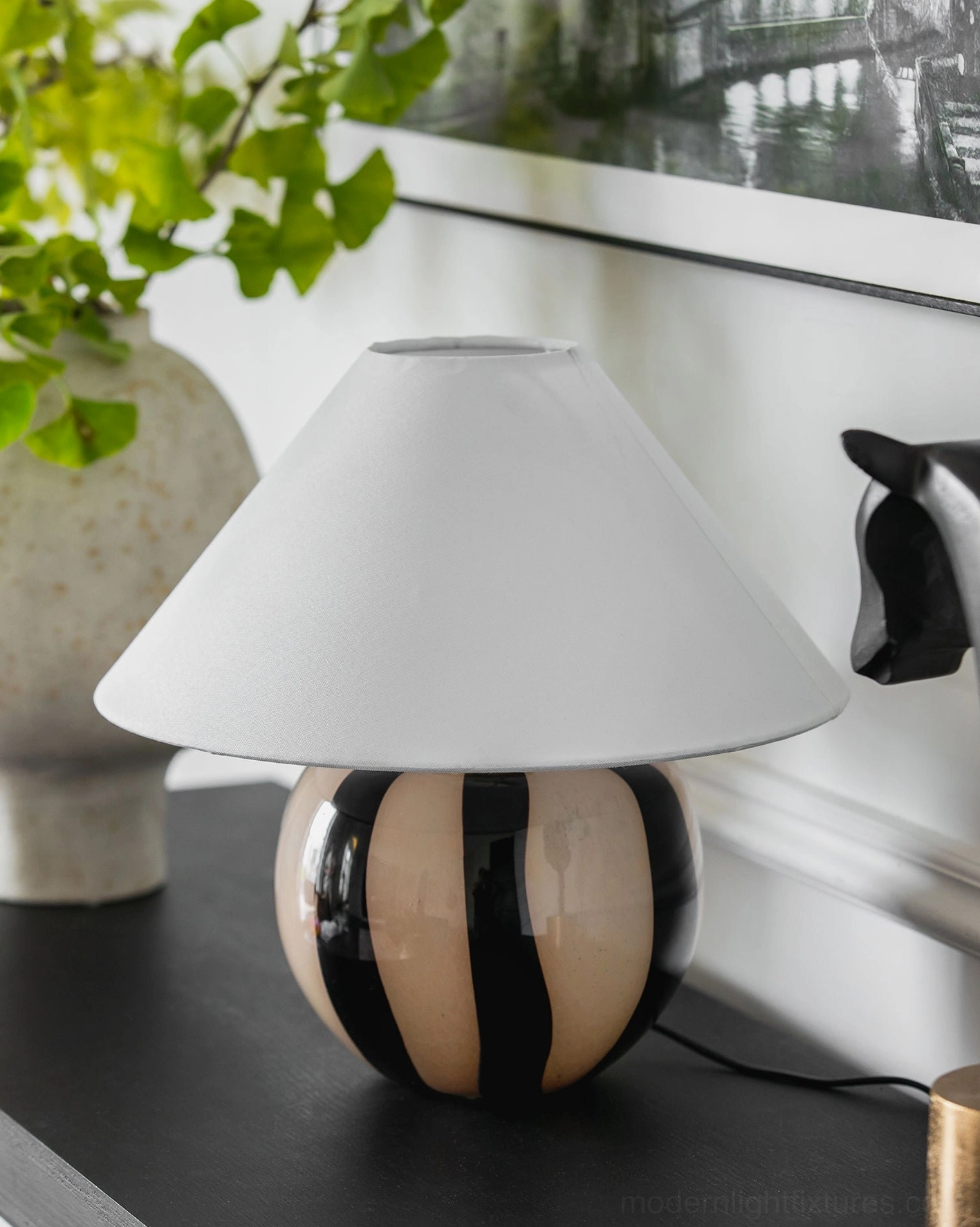 Kodhi contemporary table lamp on modern console table with potted plant and wall art, neutral interior