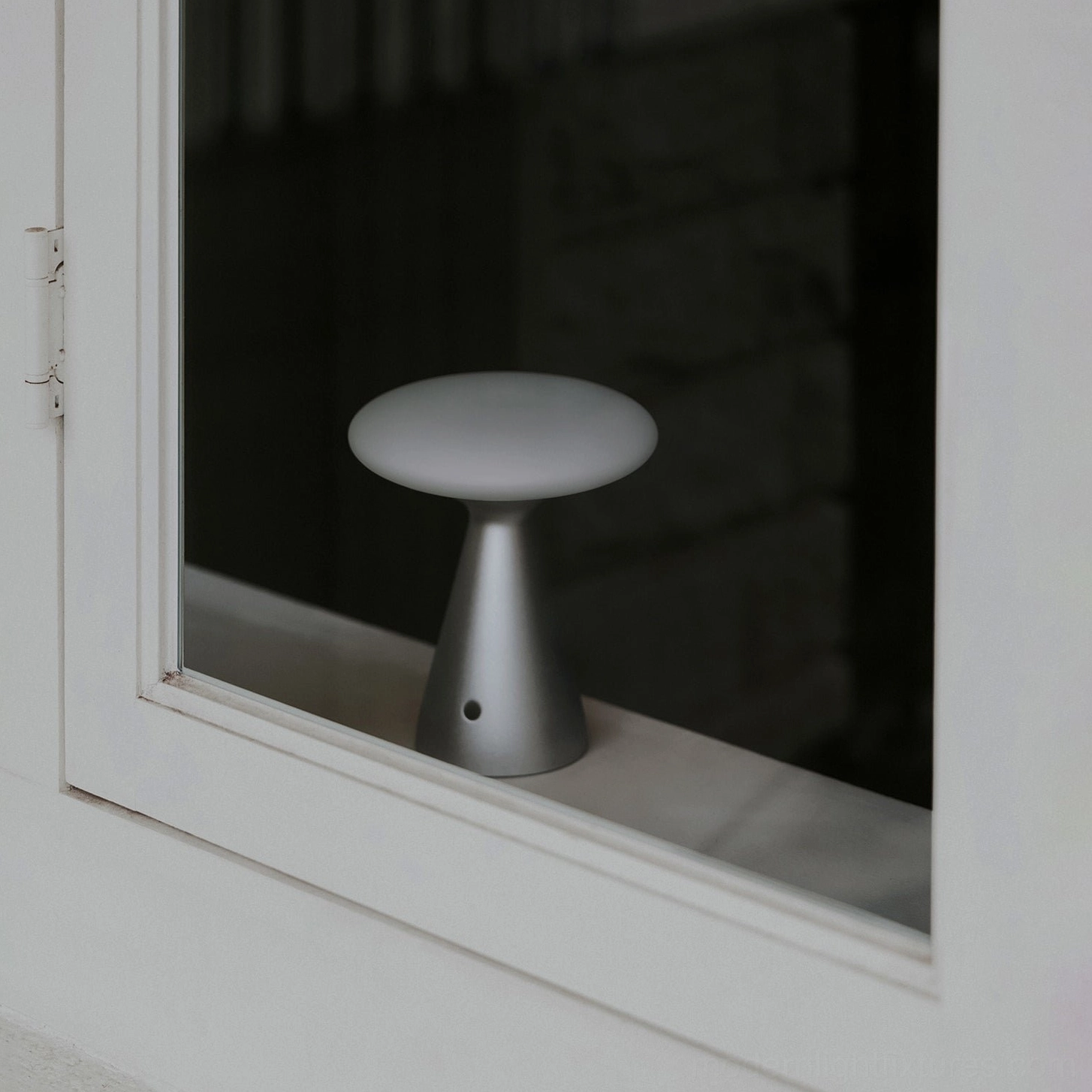 Konos minimalist table lamp in attic hallway with warm ambient accent lighting in neutral home interior - low side angle