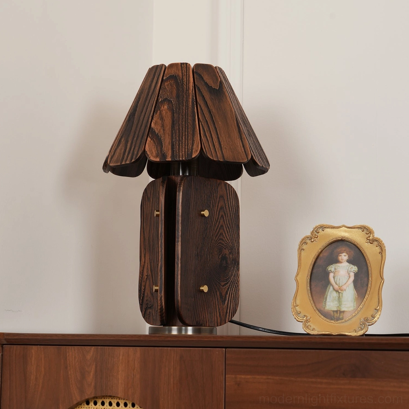 Kubec wood lamp three-quarter view on vintage wooden dresser with portrait frame accent