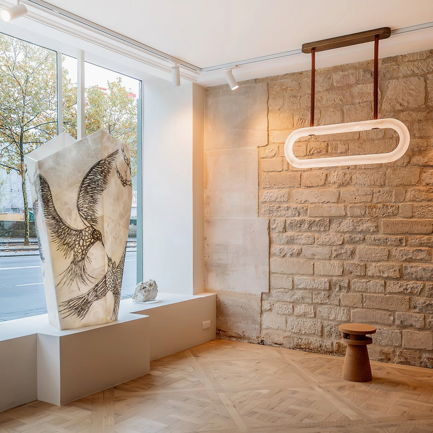 Kurve alabaster pendant light installed in modern wabi-sabi residential interior above stone accent wall with warm ambient glow