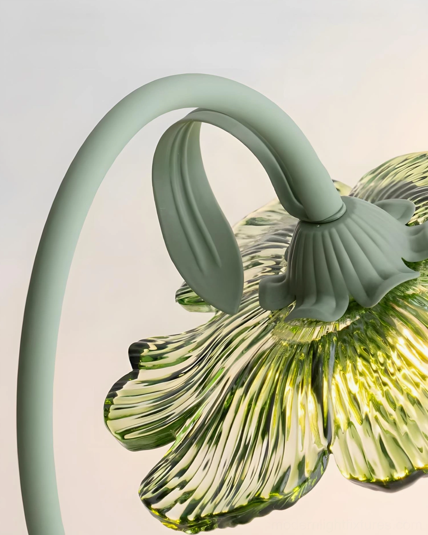 Detailed close-up of table lamp metal stem joint showing mint green finish and ribbed glass flower texture