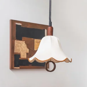 Vintage petal pendant light illuminated in warm light above dining area with wooden ceiling fixture and abstract wall art, creating intimate dining ambiance