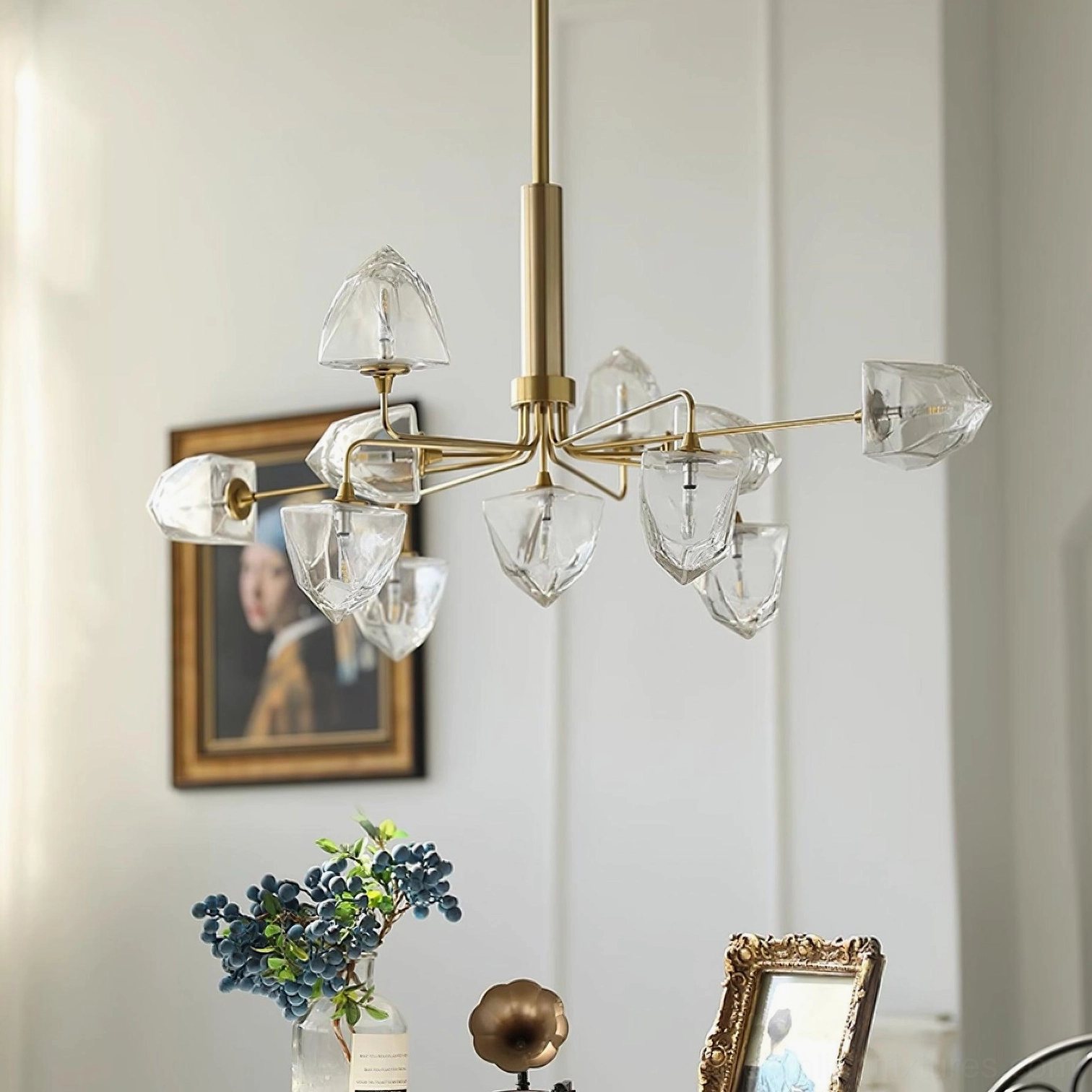 Large brass gold branch chandelier with clear faceted glass lamp shades in luxury residential living room